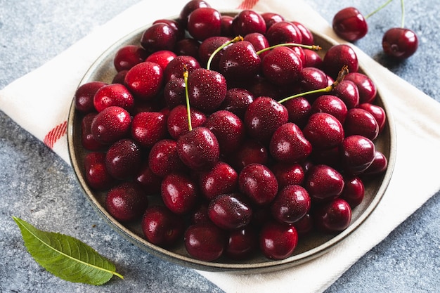 Composition de cerises douces sur une assiette avec des gouttes d'eau Concept d'été et de récolte Macro de cerise Aliments crus végétariens végétaliens