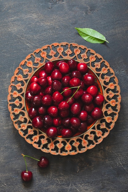 Composition de cerises douces sur une assiette avec des gouttes d'eau Concept d'été et de récolte Macro de cerise Aliments crus végétariens végétaliens