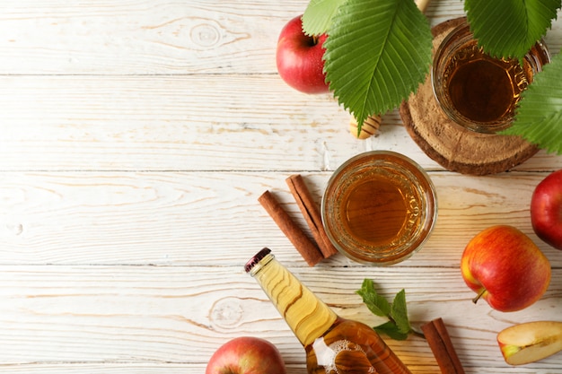 Composition avec cidre, cannelle et pommes sur bois