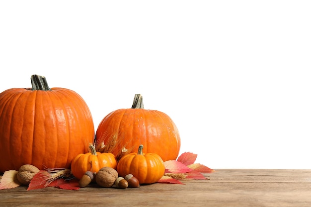 Composition avec des citrouilles mûres et des feuilles d'automne sur une table en bois sur fond blanc Joyeux jour de Thanksgiving