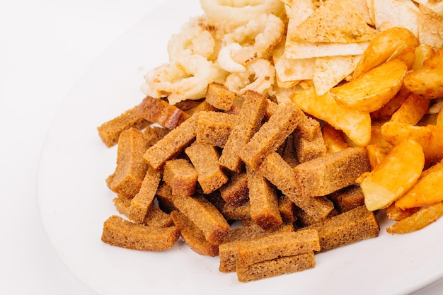 Composition de collations de restauration rapide avec des rondelles d'oignon, des craquelins, des frites de pommes de terre au four, du pain grillé