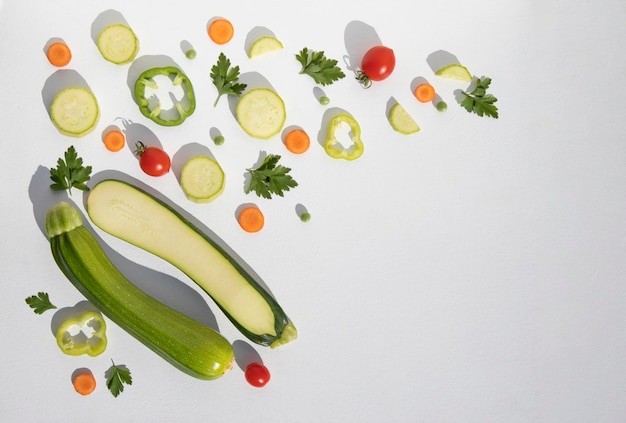 Composition de courgettes entières et tranchées avec des légumes sur une plaque blanche avec un espace pour le texte Arrière-plan avec de la nourriture