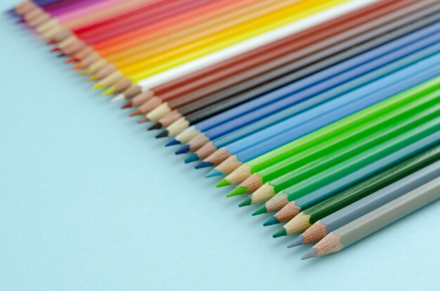 Composition de crayons de couleur sur fond bleu. Lay plat.