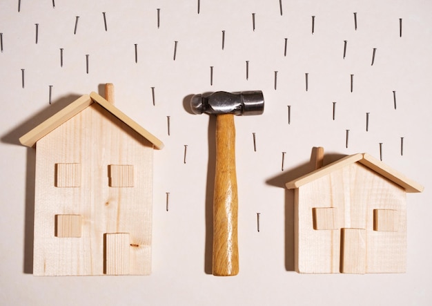 Composition créative de bois de maisons en bois sous forme de marteau et de pluie de clous le concept de construction de logements