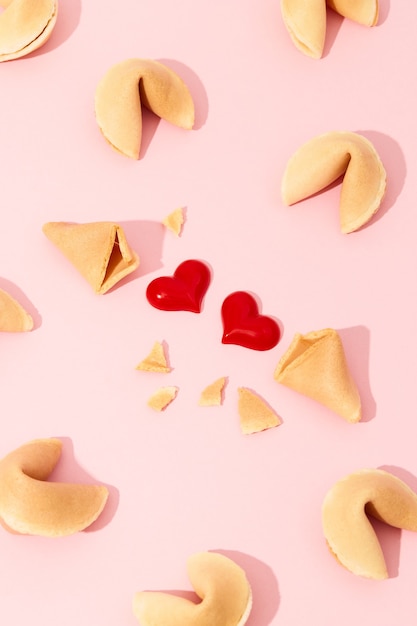 Composition créative avec fortune cookies et coeurs sur fond rose