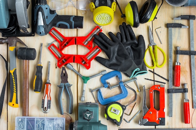 Composition créative à plat de divers outils de menuisier sur table en bois