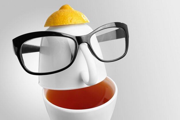 Composition créative sur le thème du thé. Tasses à thé en forme de visage humain avec des lunettes