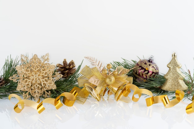 Composition de décoration de Noël boules d'or, flocon de neige, cloches et cônes avec des branches de pin