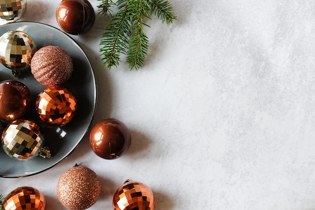 Composition avec des décorations de Noël sur assiette et arbre de Noël sur fond de béton gris