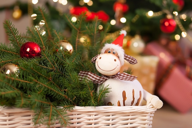 Composition avec des décorations de Noël dans le panier, sapin sur plancher en bois