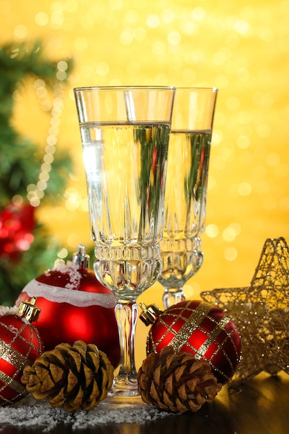 Composition avec des décorations de Noël et deux verres de champagne, sur fond clair