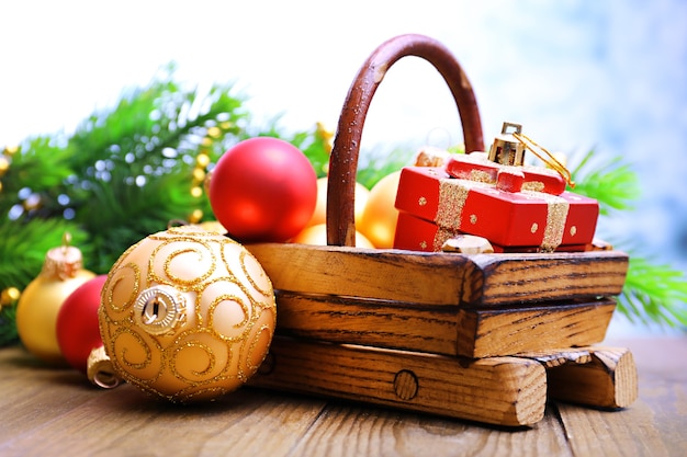 Composition avec décorations de Noël en panier, sapin sur table en bois,