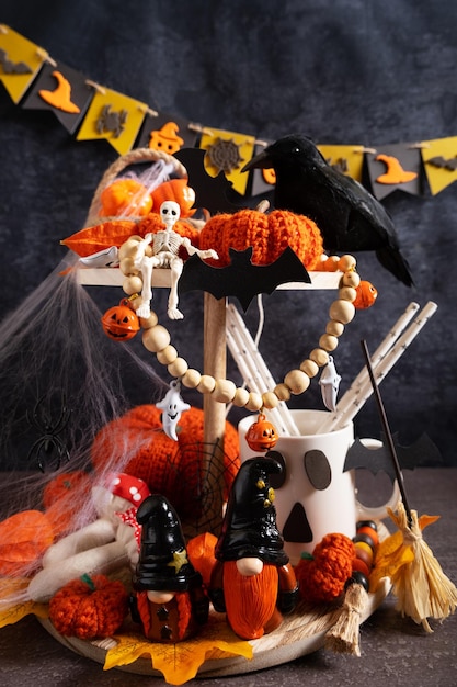 Composition décorative pour Halloween Étagère sur la table avec citrouilles toiles d'araignées squelette champignons fantômes gnomes et guirlande sur fond gris Gros plan