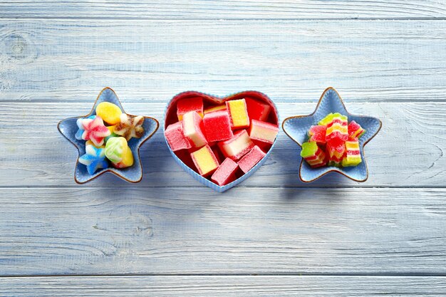 Composition avec de délicieuses bonbons à la gelée sur fond de bois