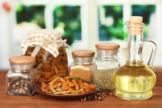 Composition de délicieux champignons marinés huile et épices sur table en bois sur fond clair