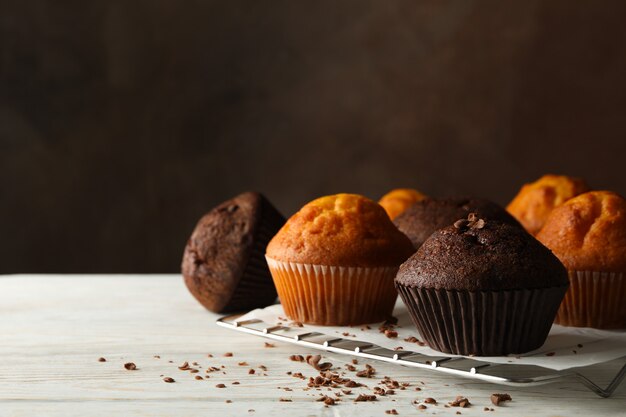 Composition avec de délicieux muffins sur fond de bois blanc