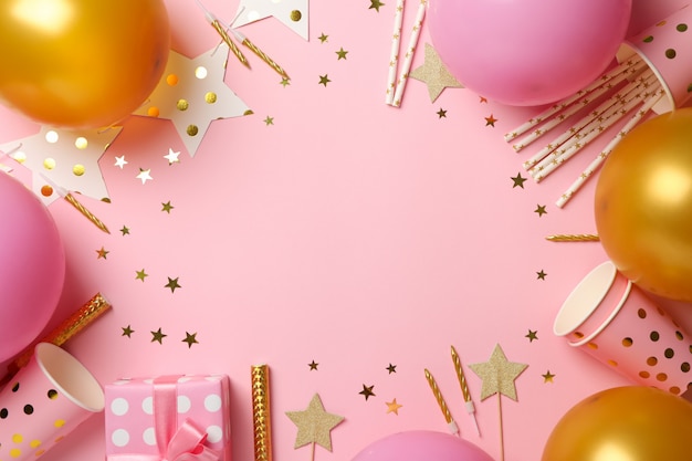 Composition avec différents accessoires d'anniversaire sur fond rose, espace pour le texte