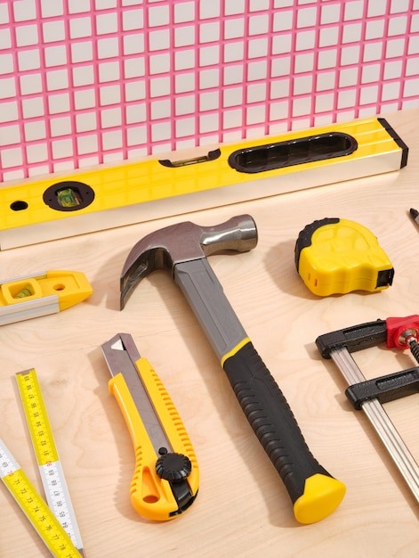 Photo composition avec différents outils de construction coupeur de boîte à marteau niveaux de bâtiment jaune et ruban de mesure