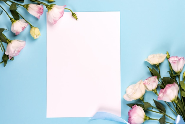 Composition Du Cadre Avec Un Espace Vide Dans Le Papier Central En Eustoma Rose Fleuri, Pose à Plat. Coins Décoratifs Floraux Sur Fond Bleu.