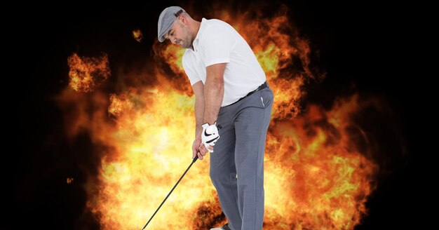 Composition du joueur de golf masculin au-dessus des flammes sur le fond noir