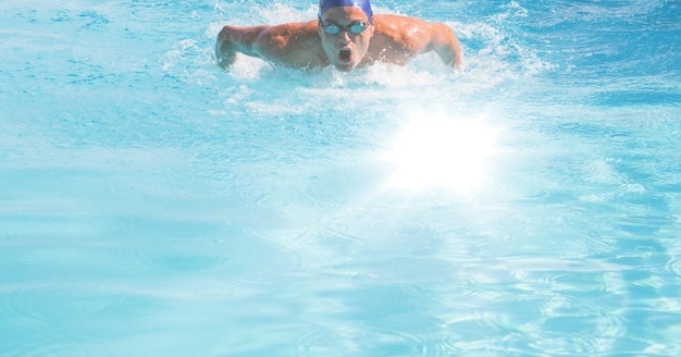Composition du nageur masculin dans la piscine avec de l'eau claire, une lumière rougeoyante et un espace de copie