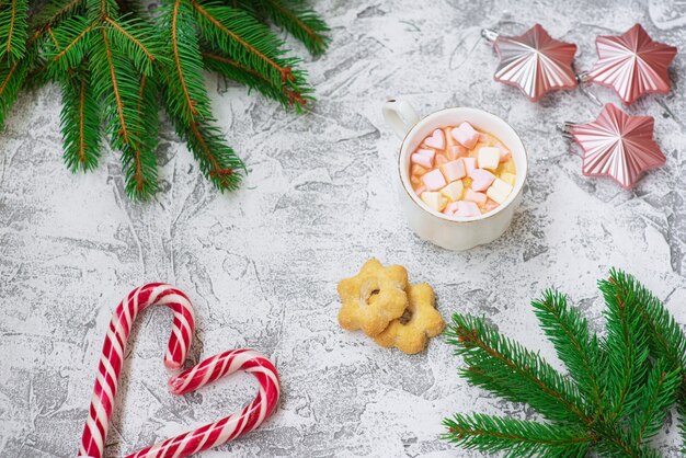 Composition du Nouvel An ou de Noël de branches vertes d'épinette, jouets du Nouvel An, tasse avec guimauves, biscuits et sucettes