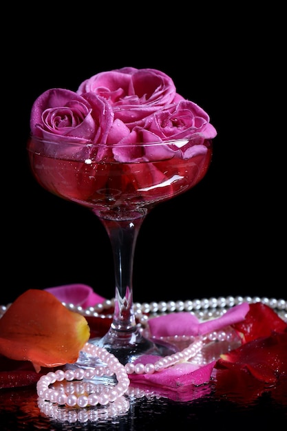 Composition Avec Du Vin Mousseux Rose Et Des Roses En Verre, Isolées Sur Fond Noir