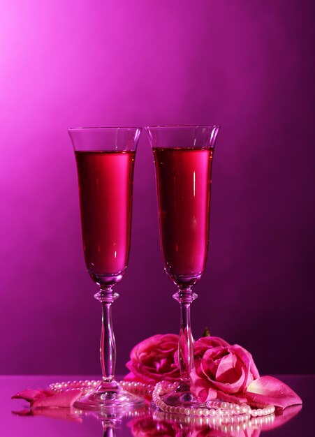 Composition avec du vin rose dans des verres et des roses sur fond de couleur foncée