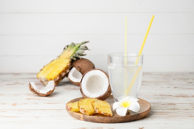 Composition avec de l'eau de coco fraîche et des fruits sur la table