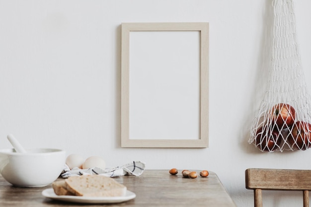 Composition élégante de design d'intérieur de salle à manger créative avec cadre d'affiche maquette table et chaise en bois bakets et autres accessoires de cuisine Modèle de murs neutres