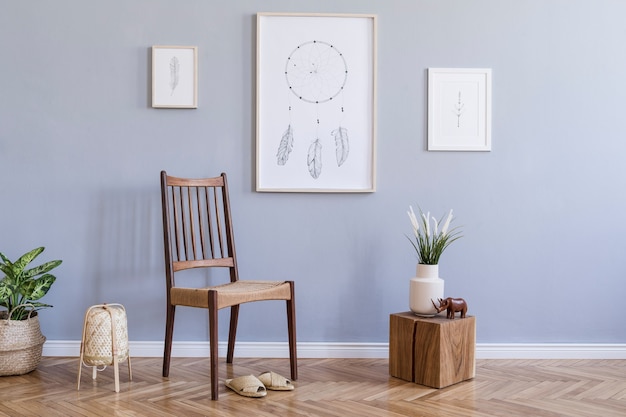 Composition élégante d'un intérieur de salon spacieux et créatif avec une maquette de cadre d'affiche, une chaise, des plantes et des accessoires. Murs gris et parquet au sol. Style bohème. Modèle