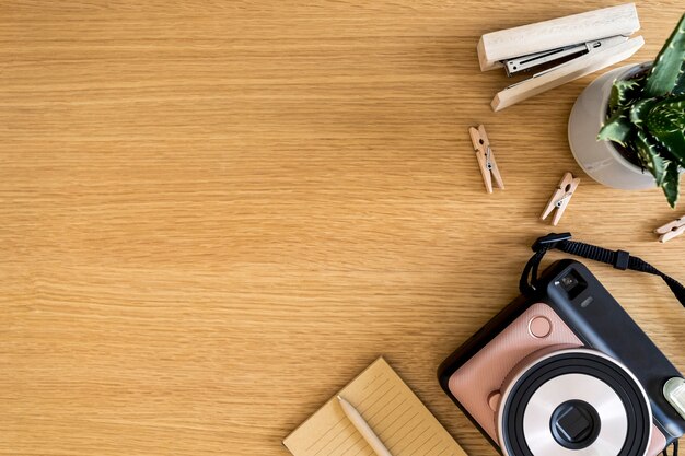 Composition d'entreprise élégante à plat sur le bureau en bois avec appareil photo, cactus, stylo, espace de copie et fournitures de bureau dans un concept moderne.