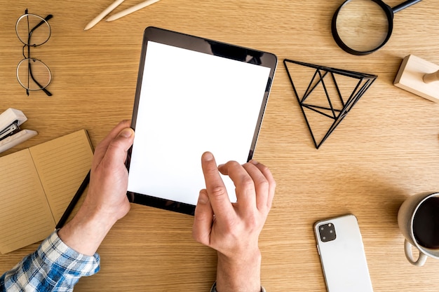 Composition d'entreprise moderne sur le bureau à domicile avec pigiste, écran de tablette maquette, plante, notes, téléphone portable et fournitures de bureau dans un concept élégant de décoration intérieure.