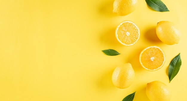 Photo composition d'été à base d'oranges, de citron et de feuilles vertes