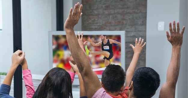 Composition d'une famille de fans de sport regardant un événement d'athlétisme à la télévision, acclamant les bras en l'air