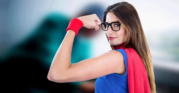 Composition de femme à lunettes habillée en super-héros fléchissant les muscles sur fond médical flou