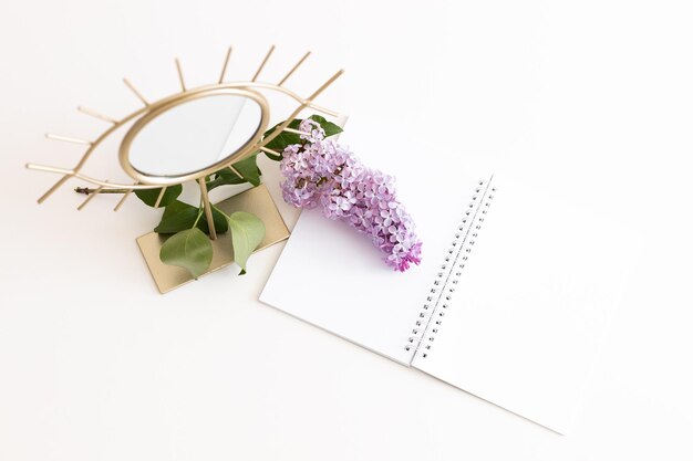 Composition Flatlay avec bloc-notes papier vierge miroir fleur lilas sur fond de bois blanc Télévision