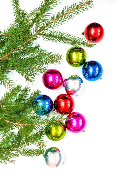 Composition flatlay de Noël avec des boules colorées et des branches de sapin. décorations du nouvel an sur fond blanc. Modèle de carte de voeux maquette, platement, vue de dessus