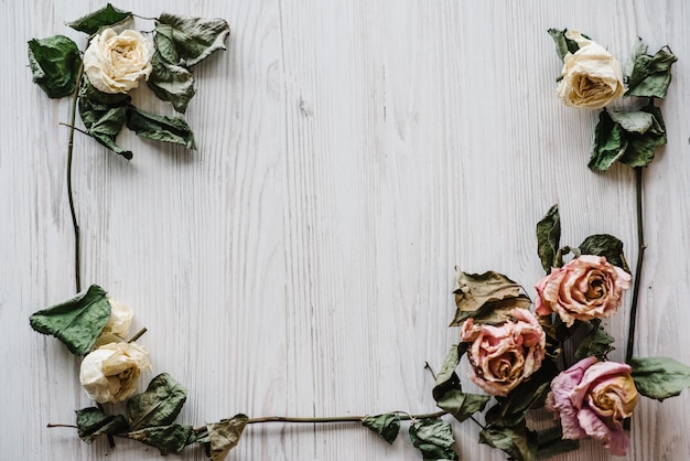 Photo composition de fleurs cadre fait de fleurs roses séchées sur fond de bois blanc mise à plat vue de dessus copiez l'espace place pour le texte et le design