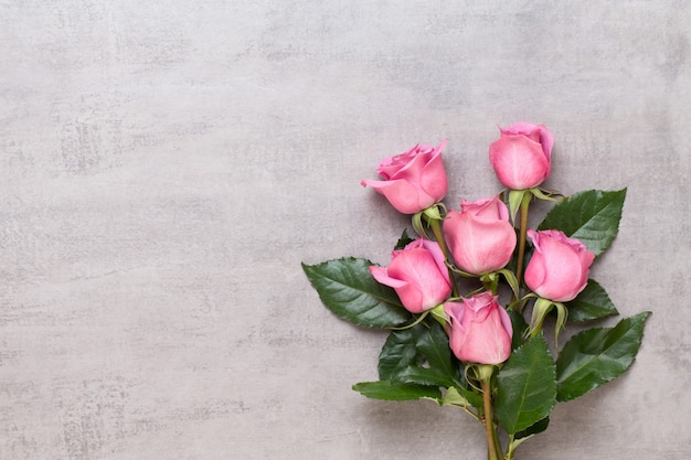 Composition de fleurs Saint Valentin. Cadre en rose rose sur fond gris. Mise à plat, vue de dessus, espace de copie.