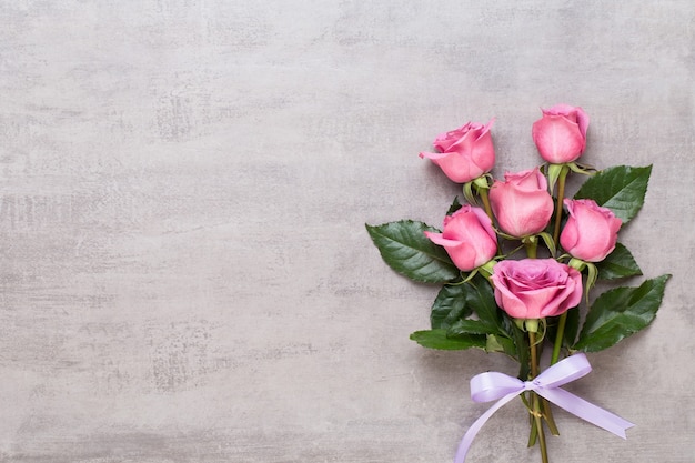 Composition de fleurs Saint Valentin. Cadre en rose rose sur fond gris. Mise à plat, vue de dessus, espace de copie.