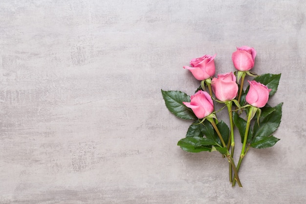 Composition de fleurs Saint Valentin. Cadre en rose rose sur fond gris. Mise à plat, vue de dessus, espace de copie.