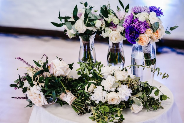 Composition de fleurs violettes blanches et de verdure sur table Close up Décor de mariage