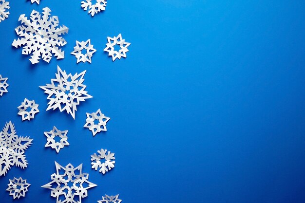 Composition avec des flocons de neige en papier sur bleu