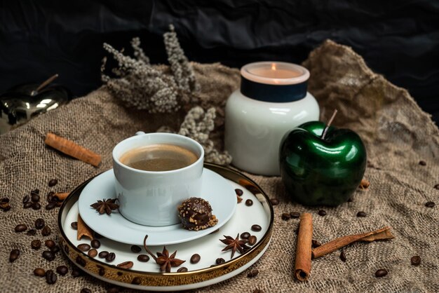 Composition de fond d'une tasse de café, bougies, pommes décoratives, épices et fleurs séchées sur un