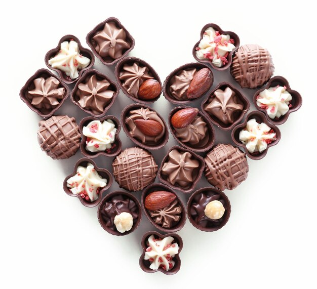 Composition en forme de coeur de bonbons au chocolat sur fond blanc