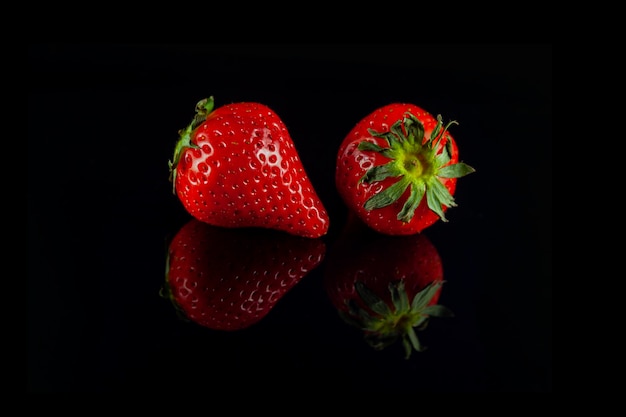 Composition de fraises fraîches sur fond noir avec reflet