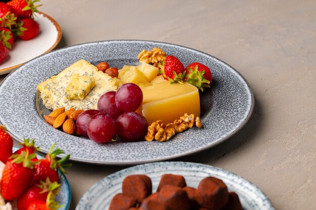 Composition de fromage et fruits sur table grise