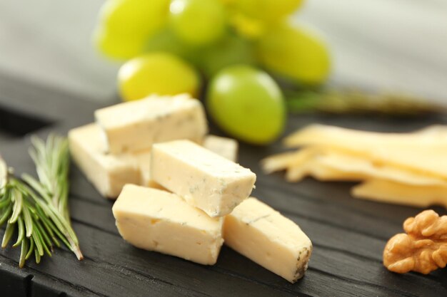 Composition de fromage en tranches et noix sur planche de bois noir