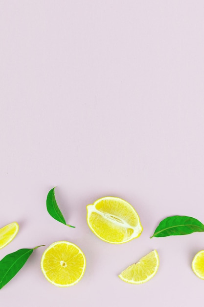 Composition de fruits et de feuilles de citron frais sur fond pastel. Concept minimal d'été, de fruits ou végétarien.